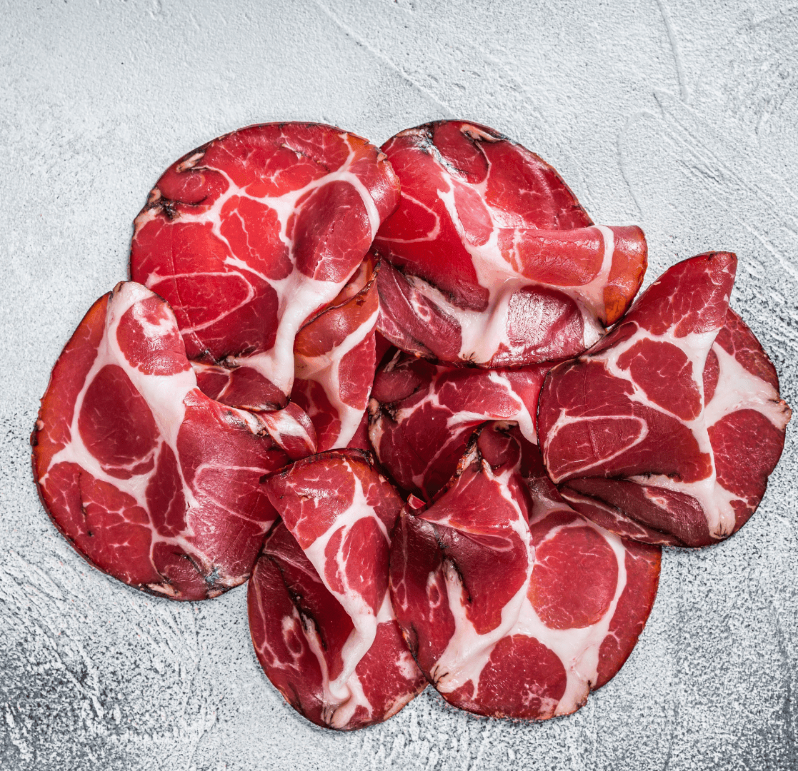 Tranches fines de Coppa Fermière artisanale corse, chair persillée, saveur douce et corsée, charcuterie Porcu Nustrale.